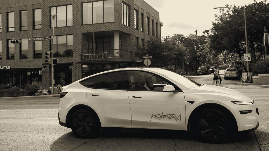 White Tesla Model Y robotaxi on Congress Avenue, Austin